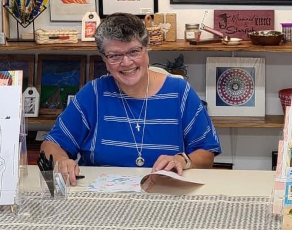 Hope Taylor Spencer smiling at a table during a book event